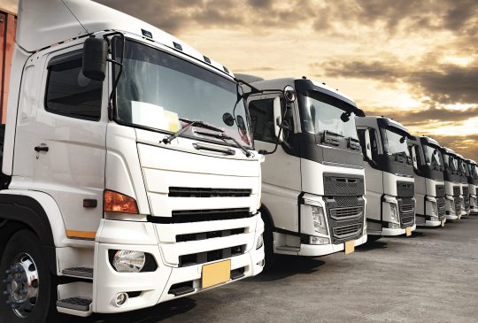 trucks-parked-lined-up-sunset-sky-road-freight-industry-logistics-transport